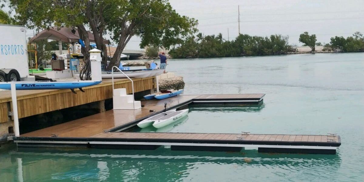 Floating dock and paddleboards at a calm shoreline used by resorts with water access for easy guest entry to the water.